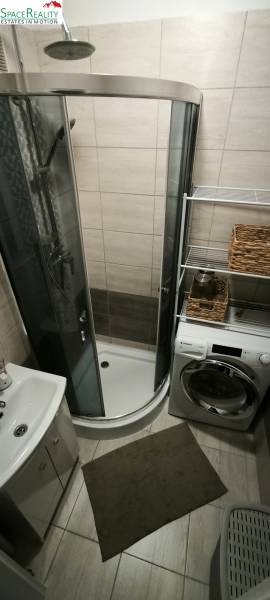 Badezimmer in einer 3-Zimmer-Wohnung mit Dusche, Waschbecken und Waschmaschine.