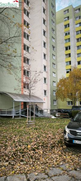 Wohnblock auf der Korytnická Straße, Bratislava - Podunajské Biskupice, umgeben von Grünflächen.