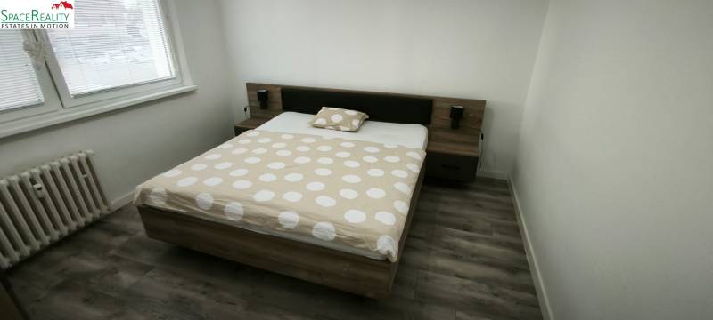 Schlafzimmer mit Doppelbett und Holzboden in einer 3-Zimmer-Wohnung.