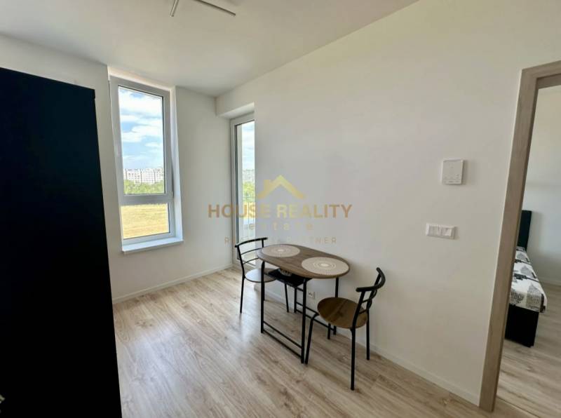 Essbereich in einer 2-Zimmer-Wohnung mit Holzboden und großen Fenstern.