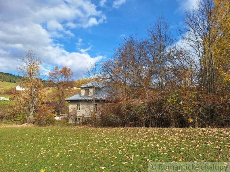 Ein Einfamilienhaus in Liptovské Beharovce, umgeben von herbstlichen Bäumen und einer grünen Wiese.
