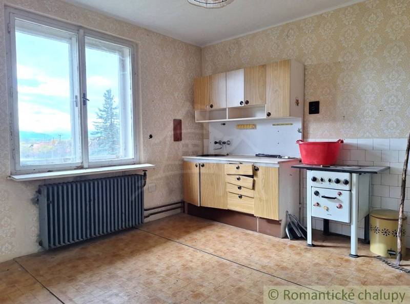 Küche in einem Einfamilienhaus mit einem Retro-Herd, einem Boden mit Holzdekor und Aussicht.