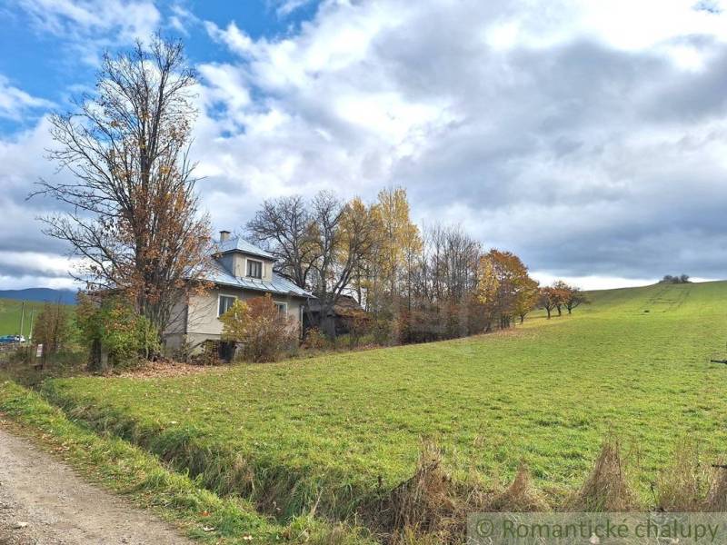 Ein Einfamilienhaus in Liptovské Beharovce, umgeben von Natur und herbstlichen Bäumen am Rande einer Wiese.