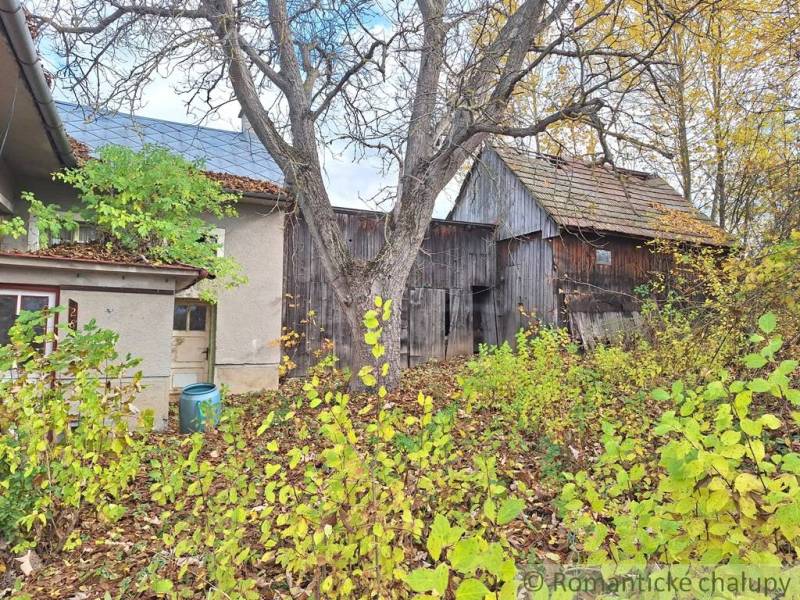 Ein Einfamilienhaus in Liptovské Beharovce, umgeben von herbstlicher Natur, Holzbauten, Bäumen.