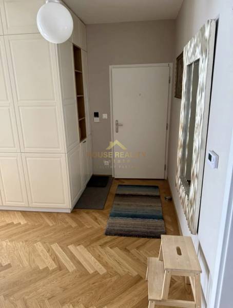 Eingangsbereich in einer 3-Zimmer-Wohnung mit Holzboden und weißen Möbeln.
