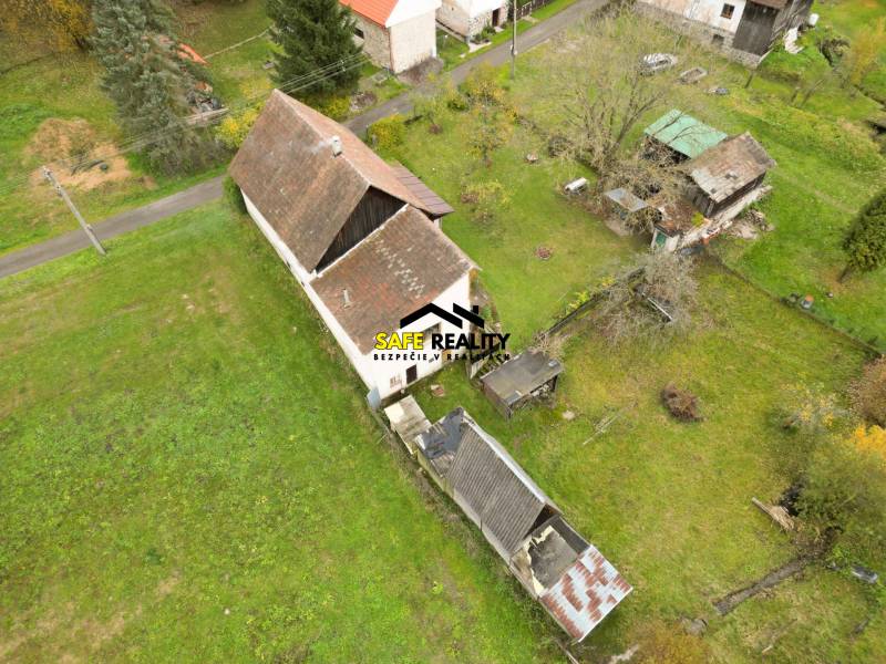 Ein Einfamilienhaus in Sklené in Sklené, umgeben von einem Garten, mit Nebengebäuden und Bäumen.