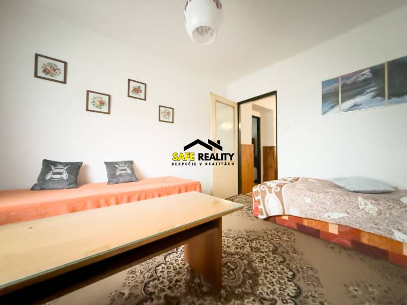 Wohnzimmer in einem Einfamilienhaus mit Teppich und Zeichnungen an der Wand.