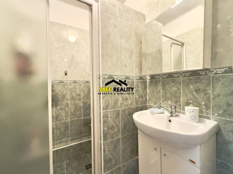 Badezimmer mit Waschbecken und Duschkabine im Einfamilienhaus.