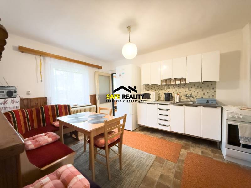 Eine Küche in einem Einfamilienhaus mit hellen Möbeln, einem Esstisch und einer Sitzecke.