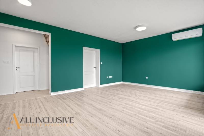 Ein Zimmer mit Holzboden, grünen Wänden und Klimaanlage, 2-Zimmer-Wohnung.