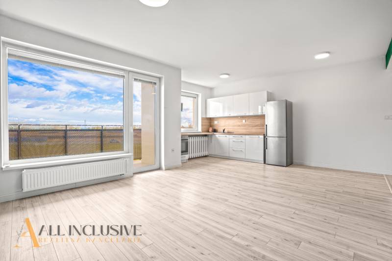 Helles Interieur einer 2-Zimmer-Wohnung mit Küche, verglaster Wand und Boden in Holzoptik.