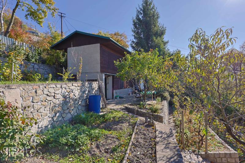 Gärten in Bratislava - Devín an der Spätná cesta, Steinmauer, Bäume und Grün.