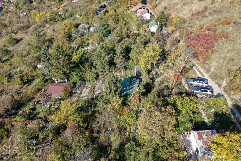 Luftaufnahme der Gärten am Spätweg in Bratislava - Devín mit Grünflächen und Hütten.