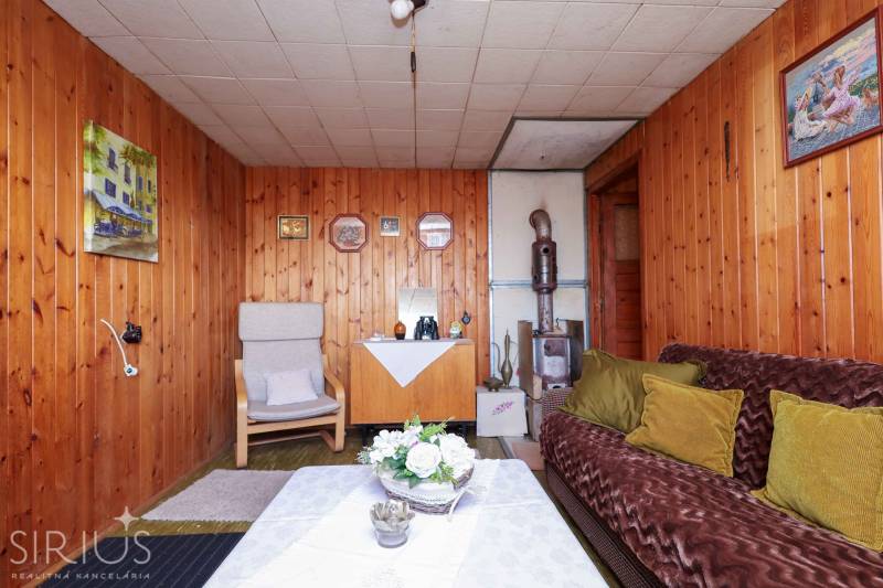 Ein Interieur mit holzgetäfelten Wänden, Kacheln und Retro-Möbeln in den Gärten.