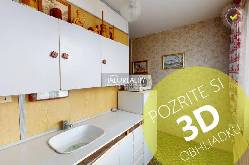 Küche in einer 3-Zimmer-Wohnung mit weißen Schränken und Bildern an den Wänden.