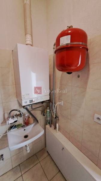 Gasheizung mit Waschbecken in Geschäftsräumen, Fliesenboden, Wände mit Fliesen verkleidet.