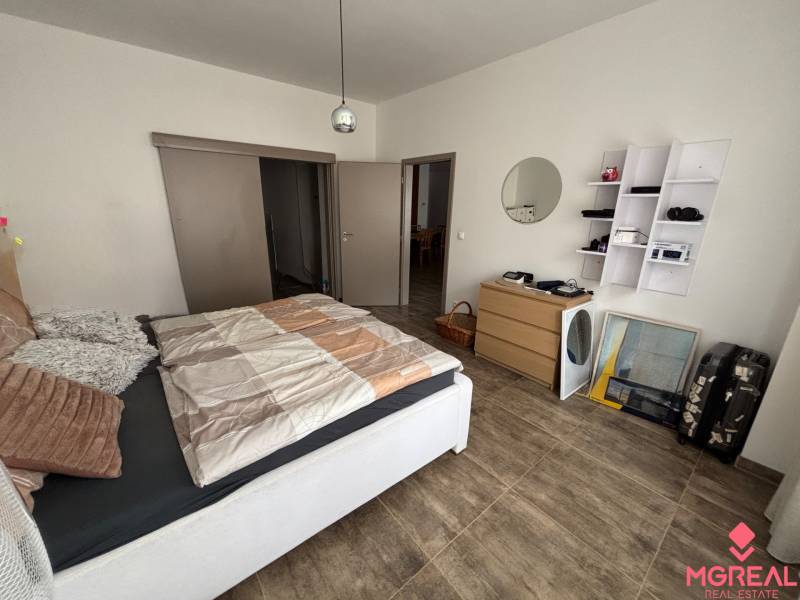 Schlafzimmer in einer 2-Zimmer-Wohnung mit Holzboden, Bett und Stauraum.