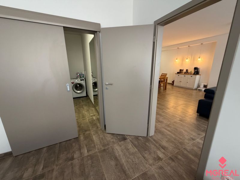 Geräumige 2-Zimmer-Wohnung mit Waschmaschine und stilvoller Beleuchtung, Boden mit Holzdekor.