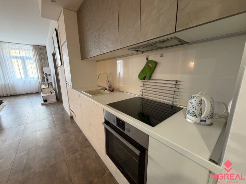 Küche mit Einbauküche, Kochfeld und Spüle in einer 2-Zimmer-Wohnung.