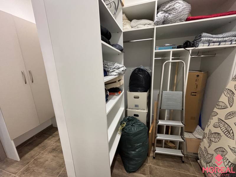 Úložný Raum in einer 2-Zimmer-Wohnung mit Regalen, Treppen und Kisten.