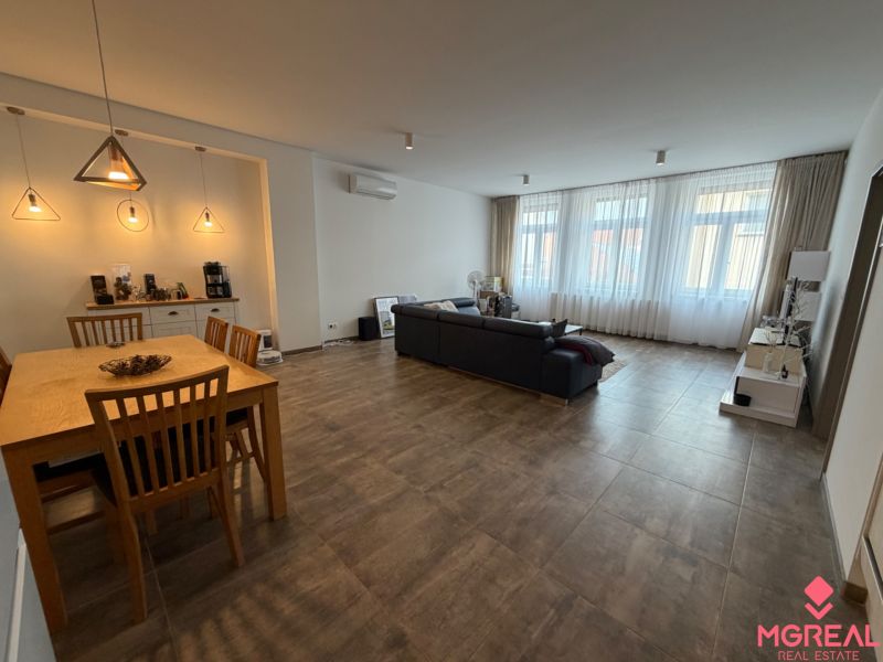 Wohnzimmer mit Holzboden in einer Zweizimmerwohnung, Ess- und Wohnbereich.