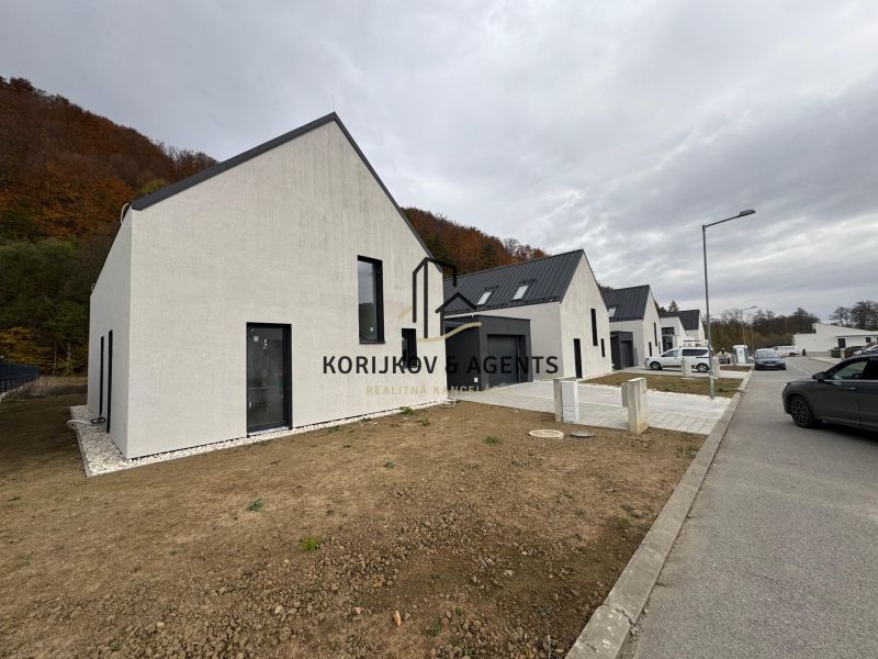 Einfamilienhaus in der Straße Pod Drieňovou in Kamenica nad Cirochou, Reihenhausbebauung mit Autos.