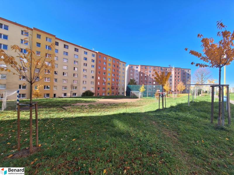 Wohngebäude in der Straße Federátov in Prešov mit einem Kinderspielplatz und Bäumen.