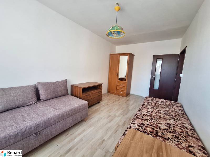 Wohnzimmer in einer 3-Zimmer-Wohnung mit Holzboden und einfacher Einrichtung.