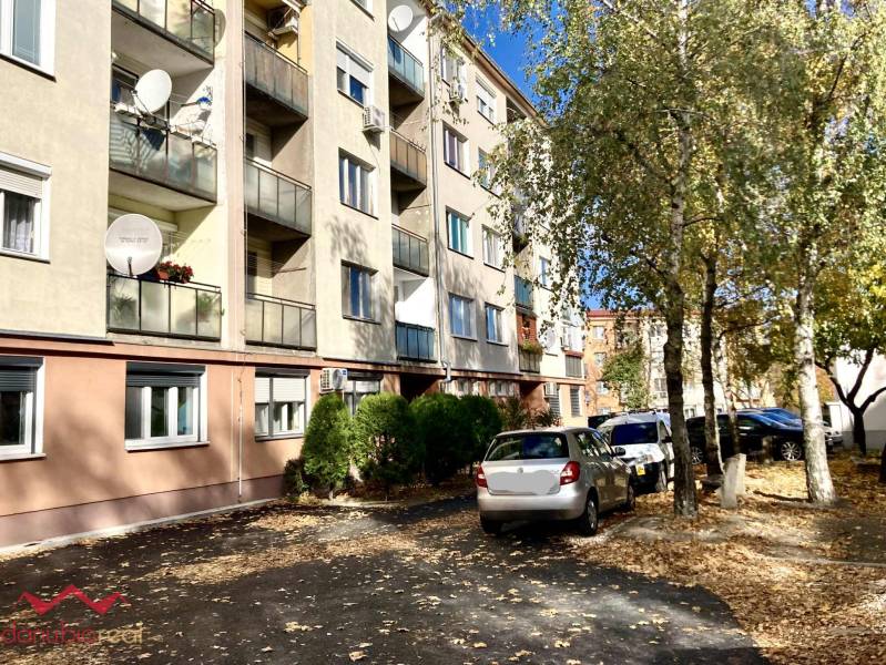 Wohnhaus in der Mederčská-Straße in Komárno mit geparkten Autos und Bäumen.