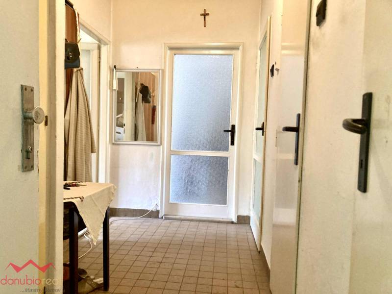 Flur in einer 3-Zimmer-Wohnung mit Fliesen, Spiegel und Leinentisch.