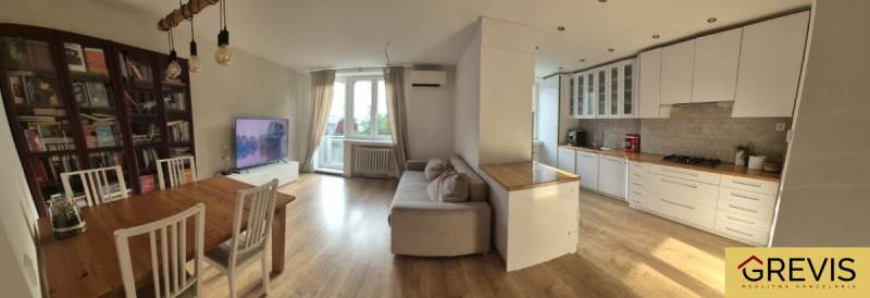 Geräumige Küche mit Wohnzimmer in einer 3-Zimmer-Wohnung. Boden mit Holzdekor, helle Möbel.