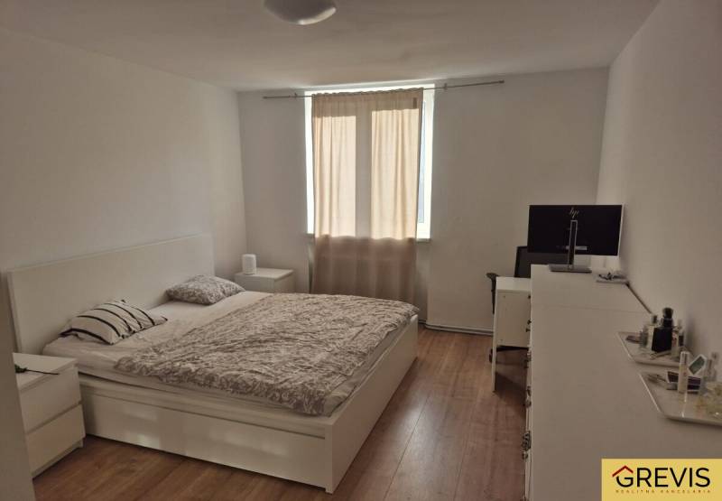 Helles Schlafzimmer in einer 3-Zimmer-Wohnung mit Bett und Holzboden.