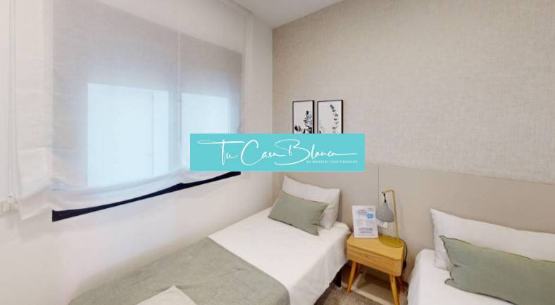 Ein Zimmer in einem Ferienapartment mit zwei Einzelbetten und zarten Wanddekorationen.