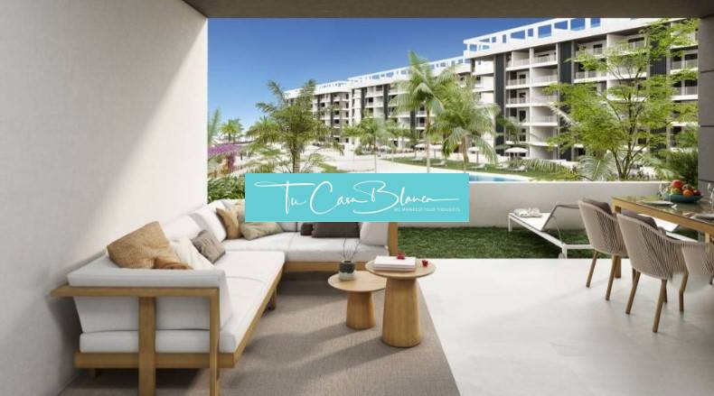 Die Terrasse des Ferienapartments in Torrevieja mit Blick auf den Pool und das Grün.