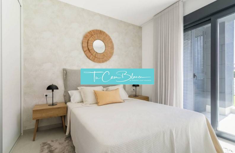 Schlafzimmer in einer Ferienwohnung, Bett, Nachttische, großes Fenster.