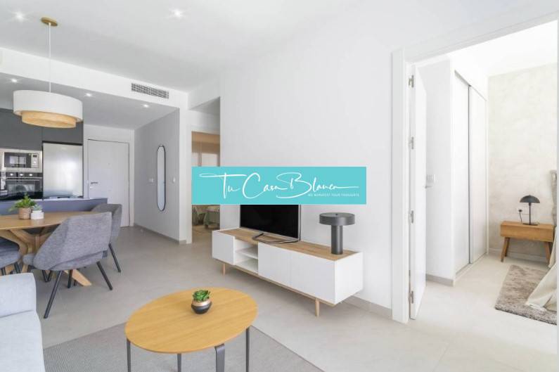 Ferienwohnung mit offenem Wohnzimmer, Esstisch und Holzboden.