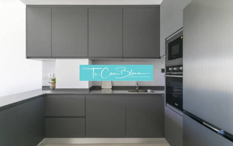 Küche in der Ferienwohnung mit dunklen Schränken und eingebauten Geräten.