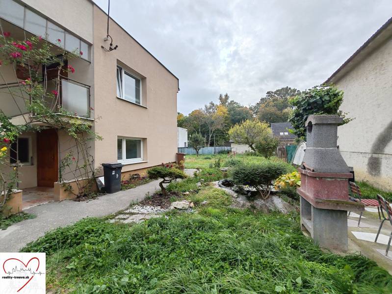 Das Einfamilienhaus in der Topoľová-Straße in Sereď hat einen grünen Garten mit einem Außenkamin.