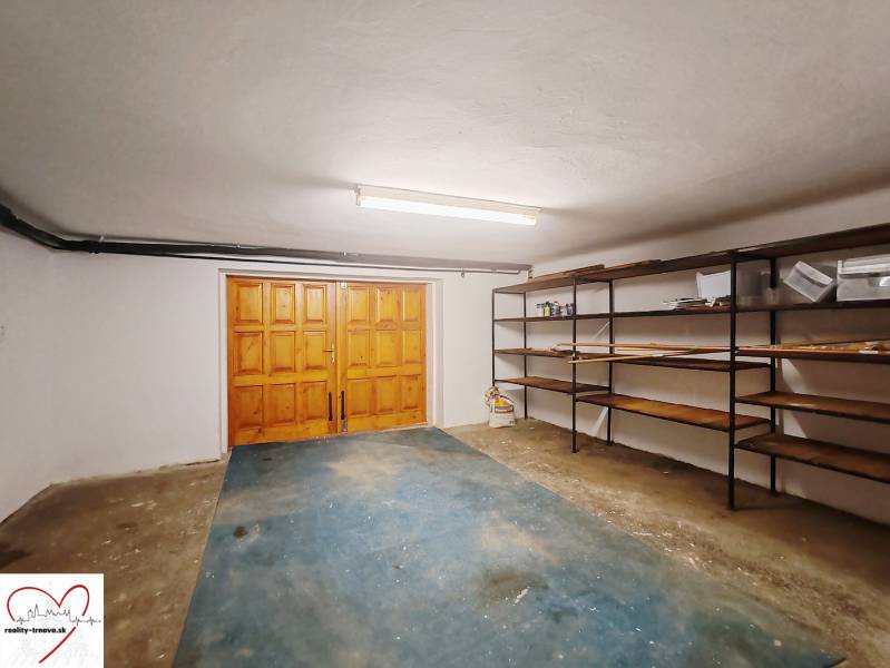Garage in einem Einfamilienhaus mit Holztüren und Regalen.