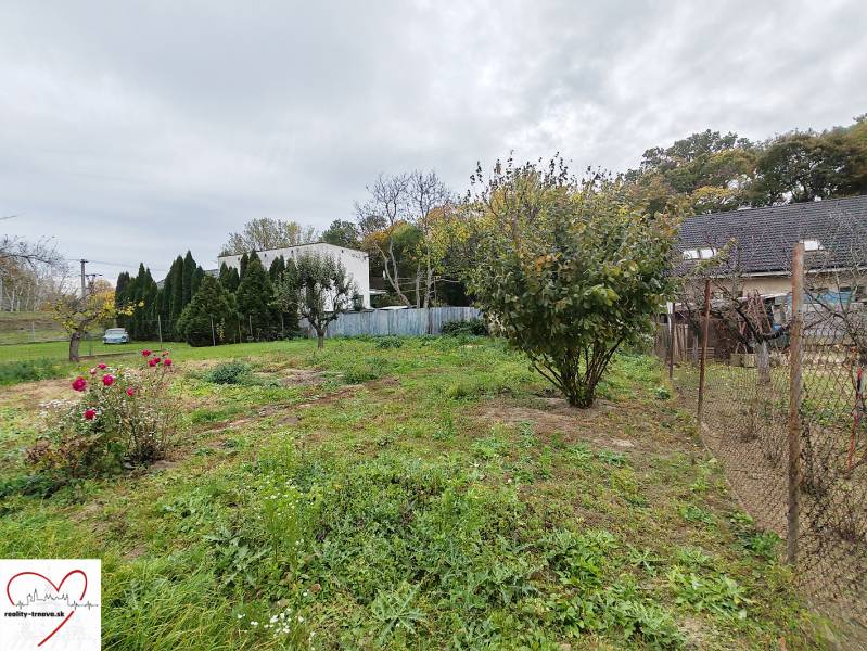 Ein Einfamilienhaus in Sereď in der Topoľová-Straße mit blühenden Rosen und Bäumen im Garten.