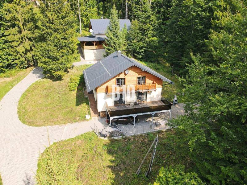 Eine Hütte in Terchová, umgeben von Wald, mit einer Sonnenterrasse und einem Zugangsweg.