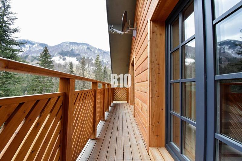 Der Balkon der Hütte in Terchová mit Blick auf die verschneiten Berge und Wälder.