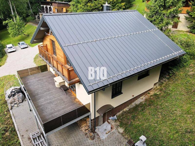 Hütte in Terchová mit schrägem Dach, großer Terrasse und Holzelementen.