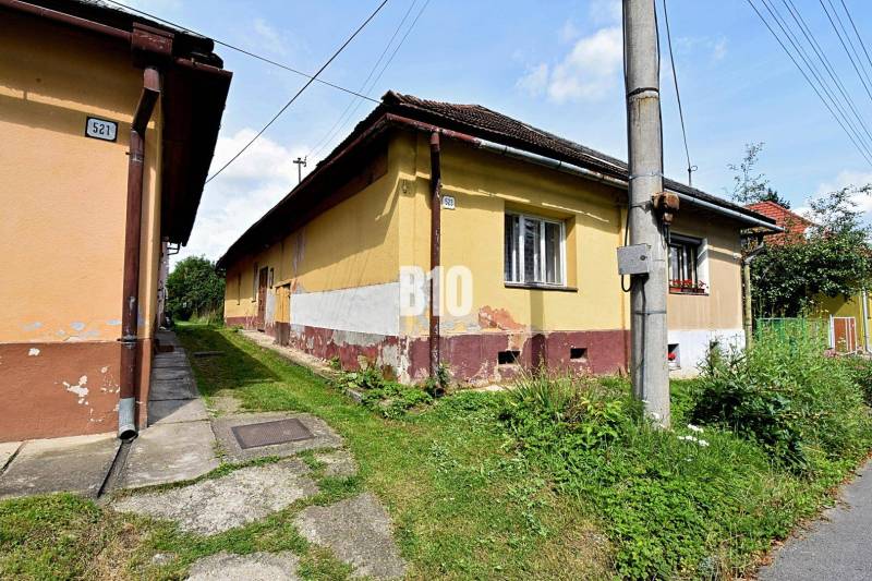 Ein Familienhaus in Partizánska Ľupča mit einem Hauch von Geschichte, umgeben von grünem Gras und einem Gehweg.