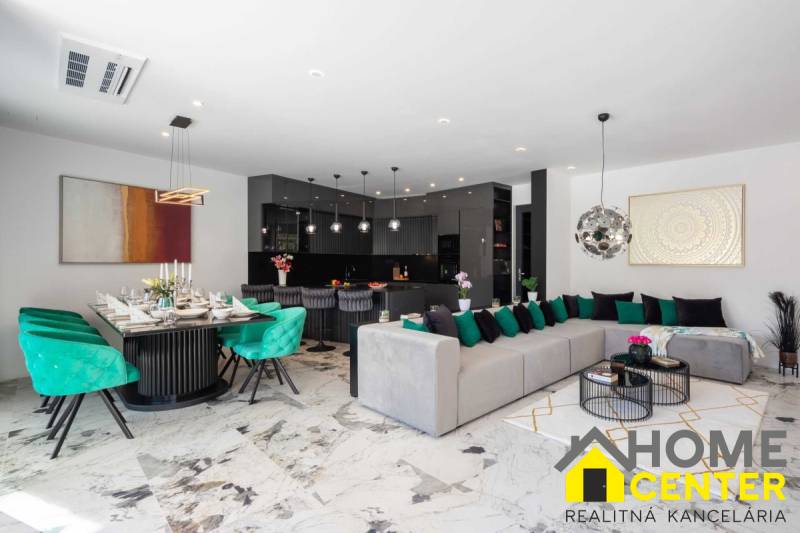 Geräumiges Wohnzimmer der Villa mit Essbereich, Sofa und moderner Küche.