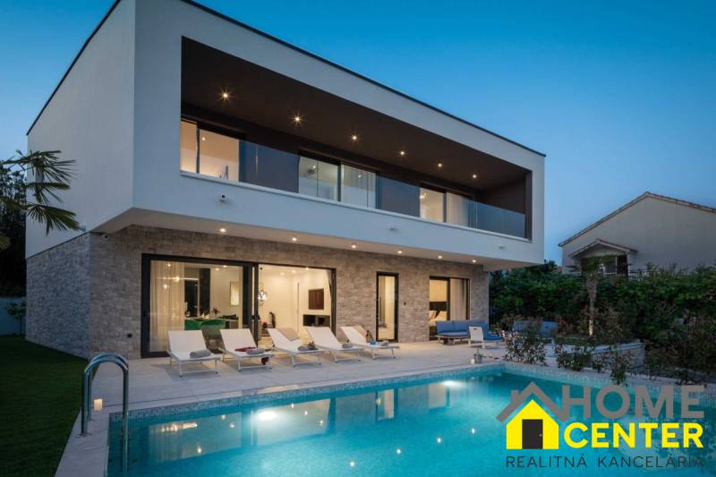 Villa in Bale mit Pool, Liegestühlen und Terrasse bei Sonnenuntergang.