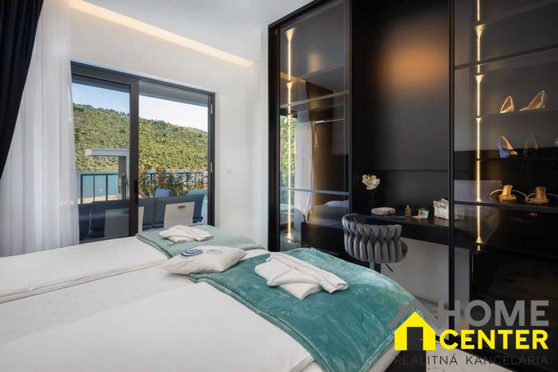 Schlafzimmer in der Villa mit Terrasse und Blick auf die Natur und den See.