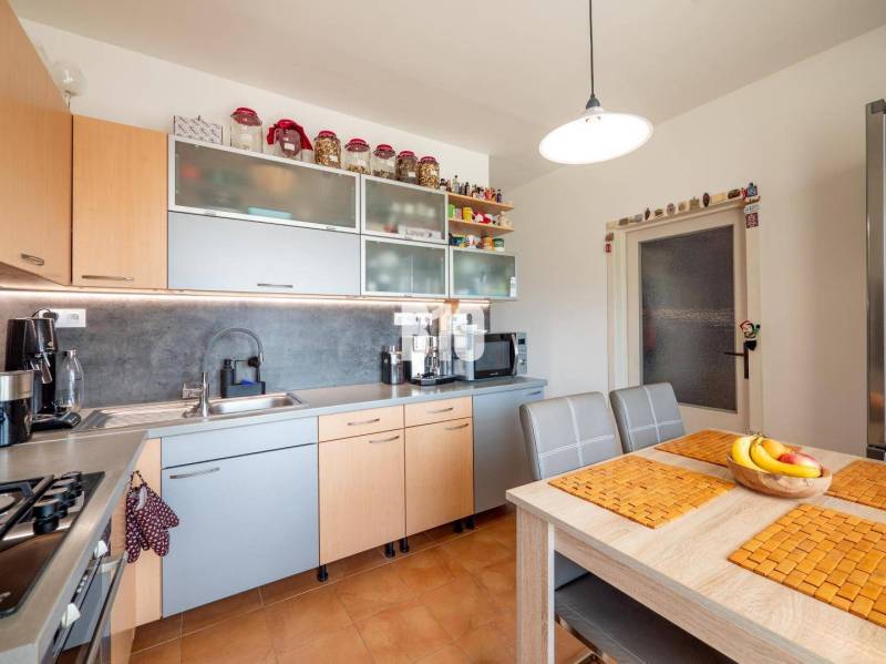 Küche in einer 4-Zimmer-Wohnung mit Computer und Küchenzeile in Holzdekor.