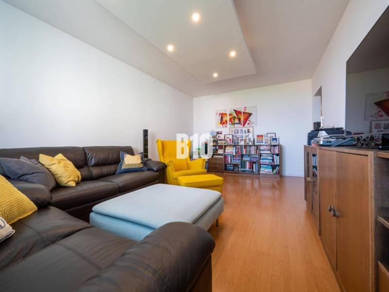 Wohnzimmer in einer 4-Zimmer-Wohnung mit Holzboden und bequemen Sitzgelegenheiten.