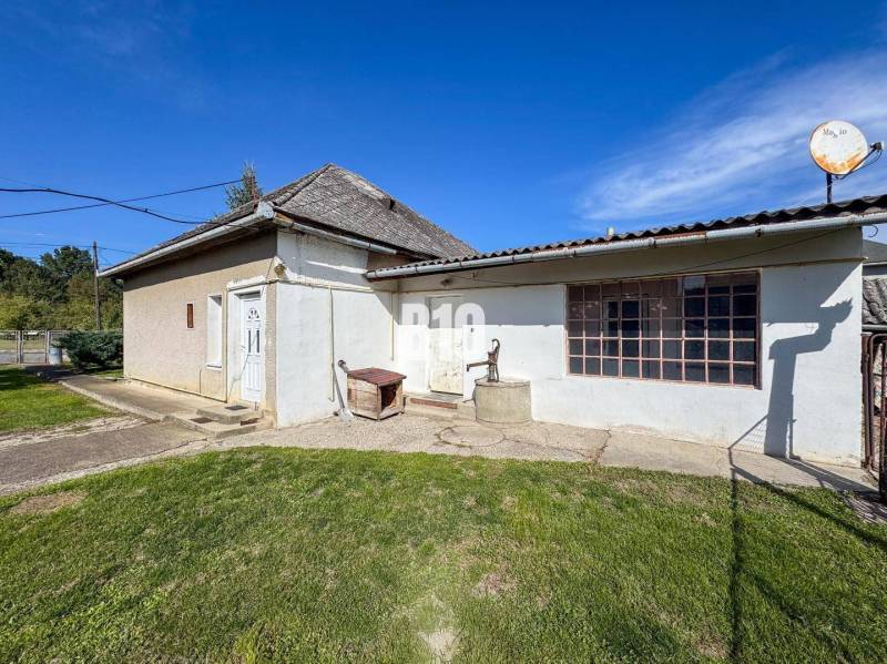 Ein Einfamilienhaus in Ondrejovce, ein älteres Gebäude mit Holzfenstern und einer Satellitenschüssel auf dem Dach.